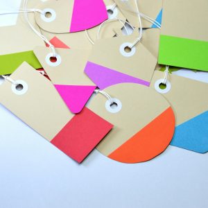 Bright and colorful paper card tags arranged on a white surface, showcasing vibrant design and shapes.