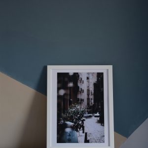 Minimalist interior featuring a framed urban photo against geometric painted wall.