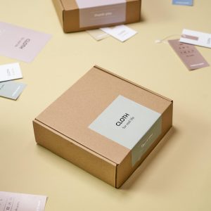 A close-up of cardboard boxes and tags on a yellow background, showcasing minimalist design.